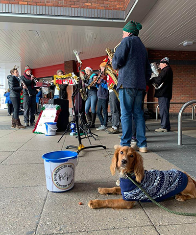 Band members busking outside Tesco with dog supporting