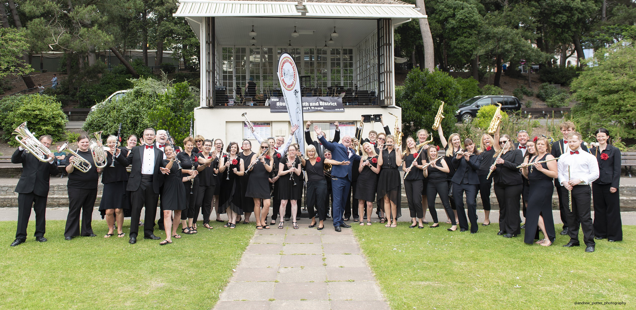 Bournemouth and District Concert Band standing in front of bandstand in Bournemouth gardens