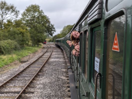 Some band members sticking their head out the steam train window