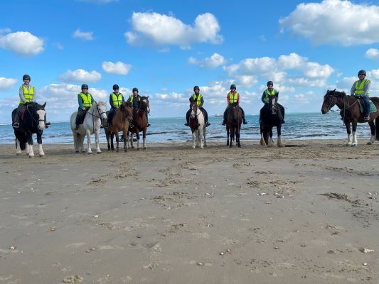 Some band members horse riding on the beach