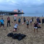 Band members picking litter on beach clean