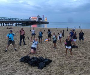 Band members picking litter on beach clean