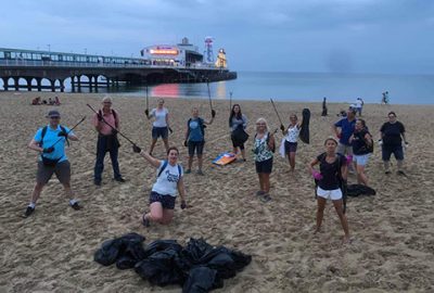 Band members picking litter on beach clean