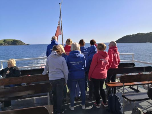 Band members on boat showing back of hoodies