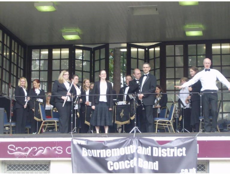 Band members standing in Bournemouth Bandstand