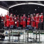 Santas playing Christmas carols on stage